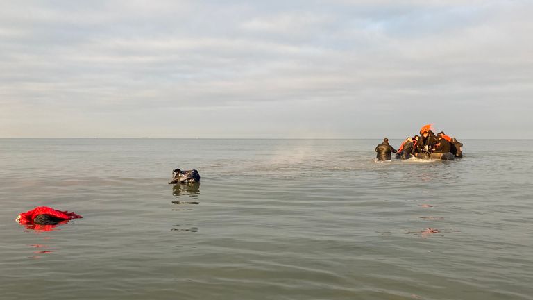 Migrants - malmener un grand bateau pneumatique sur une plage du nord de la France, pour se rendre au bord de mer afin de traverser la Manche.  - recopie d'Adam Parsons et Sophie Garratt