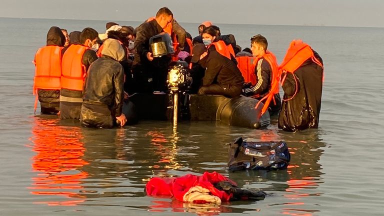 Migrants  - manhandling a large inflatable boat down a northern French beach, to get to the seafront in order to to cross the Channel.  - re copy from  Adam Parsons and Sophie Garratt