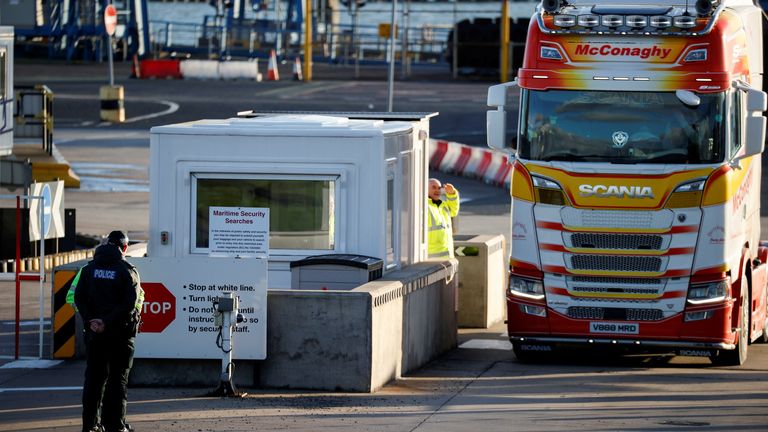 FILE PHOTO: FILE PHOTO: Police officers stand by port security as a lorry drives in at the entrance to the Port of Larne, Northern Ireland, Britain January 1, 2021. REUTERS/Phil Noble/File Photo