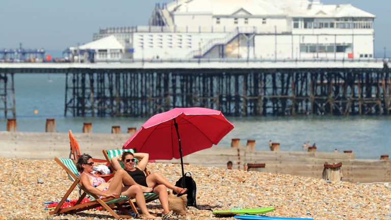 People enjoy the warm weather on the beach in Eastbourne Sussex.