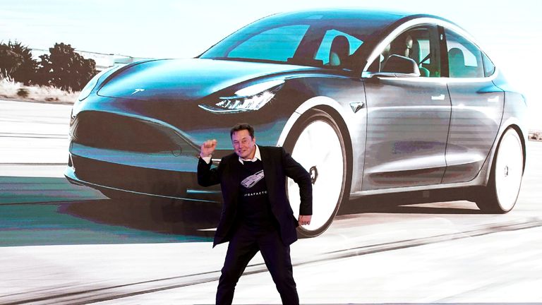 Elon Musk dances onstage during a delivery event for Tesla Model 3 cars in Shanghai