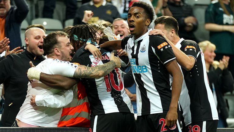 Newcastle United&#39;s Allan Saint-Maximin (hidden) celebrates scoring their side&#39;s first goal of the game with team-mates and fans during the Premier League match at St James&#39; Park, Newcastle. Picture date: Friday September 17, 2021.
