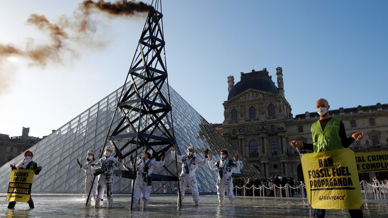 Greenpeace activists stand next to an oil drilling rig replica in front of the glass pyramid of the Louvre museum during a protest in Paris as part of the launching of an European Citizens&#39; Initiative (ECI) petition by 20 organisations calling for a new law that bans fossil fuel advertising and sponsorship in the European Union, France, October 6, 2021. REUTERS/Gonzalo Fuentes