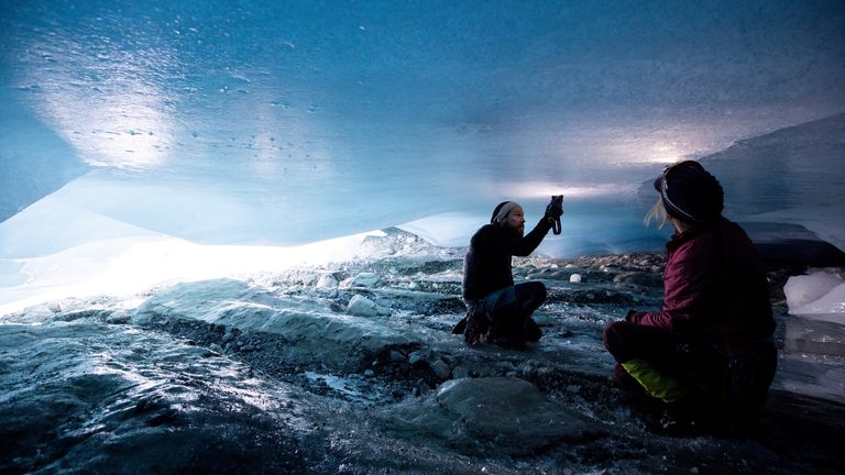 Glaciologists Andrea Fischer and Martin Stocker-Waldhuber, from the Austrian Academy of Sciences, inspect a crack in the ceiling of a natural glacier cavity of the Jamtalferner glacier near Galtuer, Austria, October 15, 2021. Giant ice caves have appeared in glaciers accelerating the melting process faster than expected as warmer air rushes through the ice mass until it collapses. Picture taken October 15, 2021. REUTERS/Lisi Niesner
