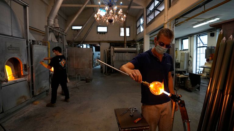 A glass-worker finishes a glass artistic creation in a factory in Murano island, Venice. Pic: AP