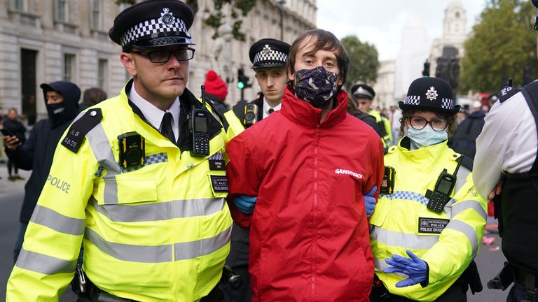 One of Campaigners from Greenpeace is led away by police outside Downing Street, London, during a protest against the Cambo oil field off the west coast of Shetland. Picture date: Monday October 11, 2021.

