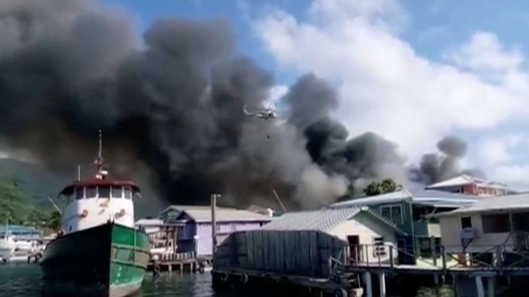 Smoke billows from a fire at a residential area on the island of Guanaja, Honduras