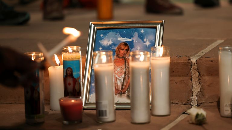 A photo of cinematographer Halyna Hutchins, who died after being shot by Alec Baldwin on the set of his movie "Rust", rests among candles at a vigil in Albuquerque, New Mexico, U.S., October 23, 2021. REUTERS/Kevin Mohatt