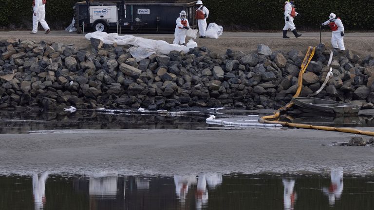 Clean-up crews work to mitigate the damage in an ecological estuary after a major oil spill off the coast of California came ashore in Huntington Beach, California, U.S. October 4, 2021