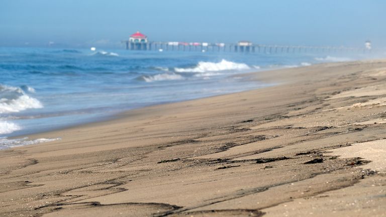 Patches of an oil spill wash off the beach south of the Pier in Huntington Beach, Calif., Sunday, Oct. 3, 2021. Pic: AP