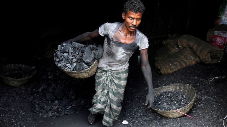 FILE PHOTO: A worker carries coal in a basket in a industrial area in Mumbai, India May 31, 2017. REUTERS/Shailesh Andrade/File Photo
