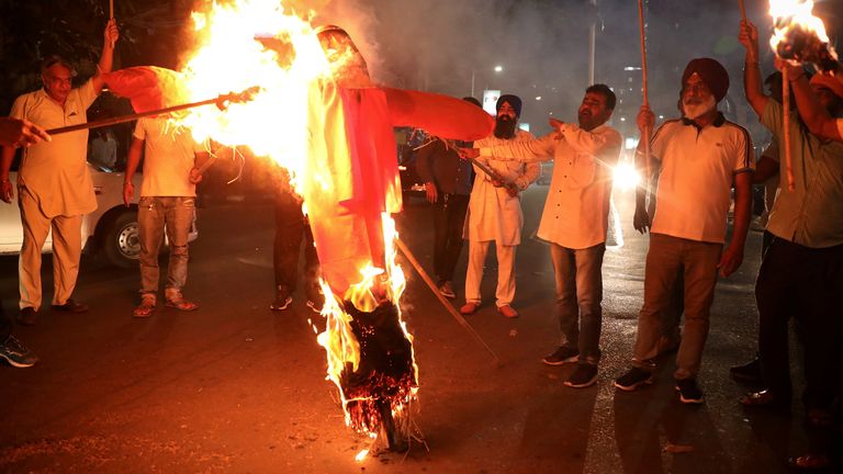 Protestors burn an effigy of Yogi Adityanath, chief minister of the northern state of Uttar Pradesh, after people were killed in the car crash