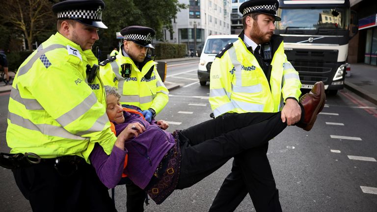 Police officers carry an Insulate Britain activist during a protest in London, Britain October 25, 2021. REUTERS/Henry Nicholls
