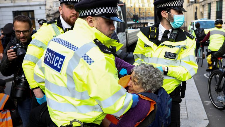 Des policiers portent un militant d'Isulate Britain lors d'une manifestation à Londres, en Grande-Bretagne, le 25 octobre 2021. REUTERS/Henry Nicholls