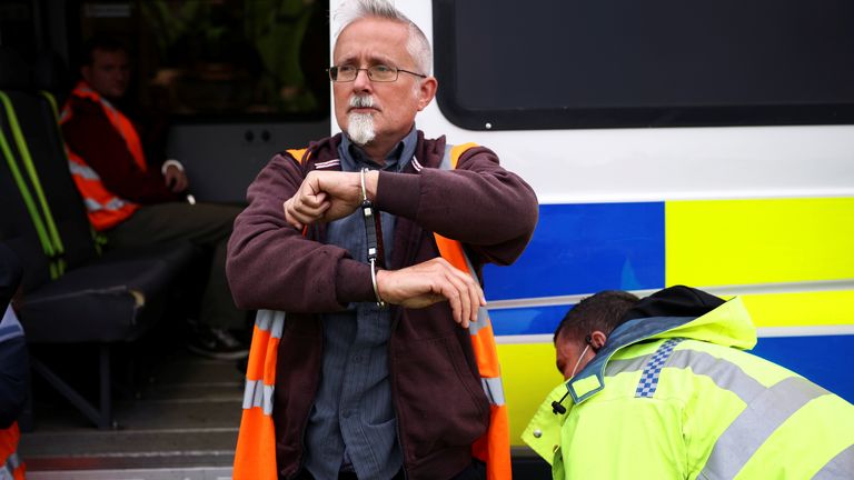 An Insulate Britain activist is handcuffed as demonstrators block a roundabout at a junction on the M25 motorway during a protest in Thurrock, Britain October 13, 2021. REUTERS/Henry Nicholls
