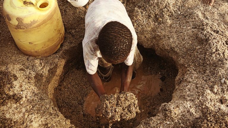 Children in a water hole dug into the Nakiria river bed, Turkana County 