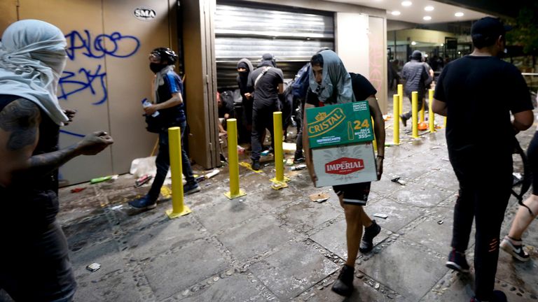 People loot a supermarket on the two-year anniversary of the start of anti-government mass protests over inequality, in Santiago, Chile, Monday, Oct. 18, 2021. (AP Photo/Luis Hidalgo)
PIC:AP