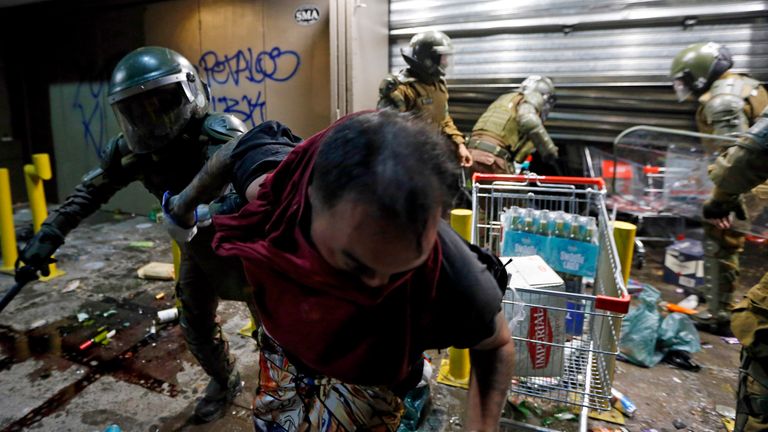 Police arrest a person as he tries to loot a supermarket on the two-year anniversary of the start of anti-government mass protests over inequality, in Santiago, Chile, Monday, Oct. 18, 2021
PIC:AP
