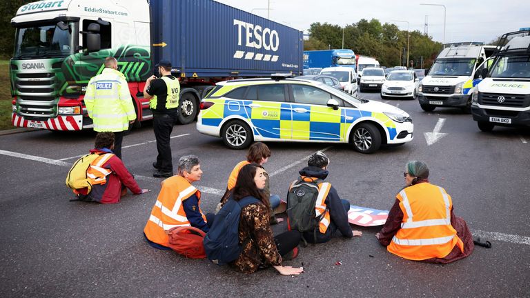 Insulate Britain activists with their hands glued to the ground block a roundabout at a junction on the M25 motorway during a protest in Thurrock, Britain October 13, 2021. REUTERS/Henry Nicholls
