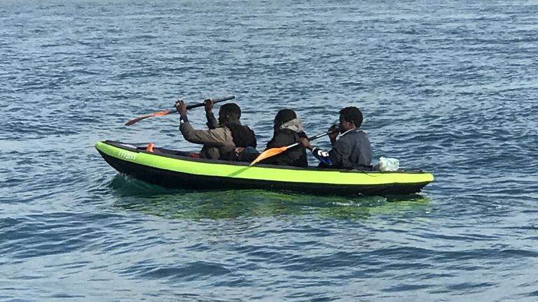 Bateau différent de la copie principale - 3 hommes dans un bateau pneumatique Re:Migrants - manipulant un grand bateau pneumatique sur une plage du nord de la France, pour se rendre au bord de mer afin de traverser la Manche.  - recopie d'Adam Parsons et Sophie Garratt