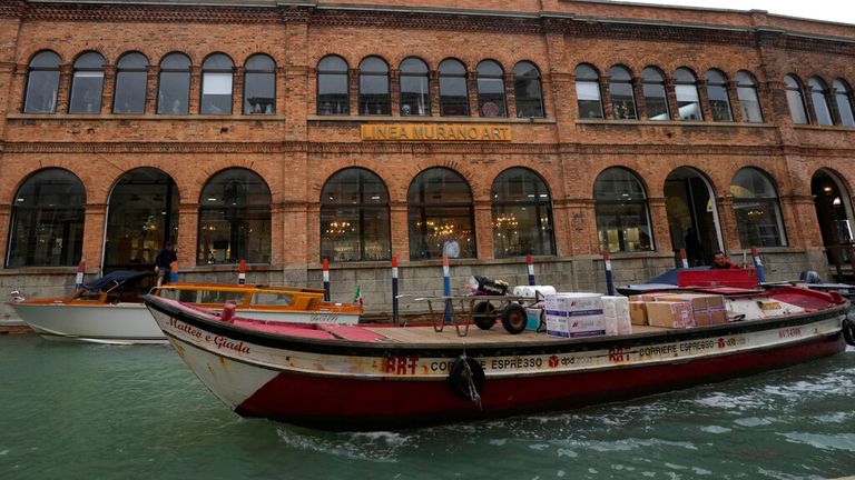 A boat sails past a historical artistic glass factory in Murano island, Venice. Pic: AP