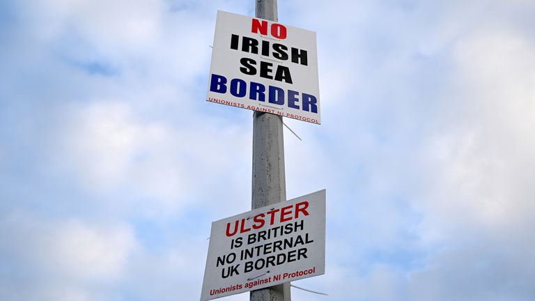 FILE PHOTO: Signs reading &#39;No Irish Sea border&#39; and &#39;Ulster is British, no internal UK Border&#39; are seen affixed to a lamp post at the Port of Larne, Northern Ireland, March 6, 2021. REUTERS/Clodagh Kilcoyne/File Photo