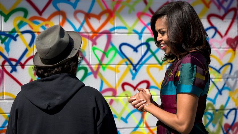 First lady Michelle Obama looks to artist Mr. Brainwash during a live painting of a Let Girls Learn mural at Union Market in Washington, Tuesday, March 8, 2016. Pic: AP