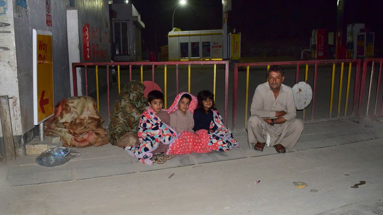 A family gather outside their house following the tremor Pic: AP