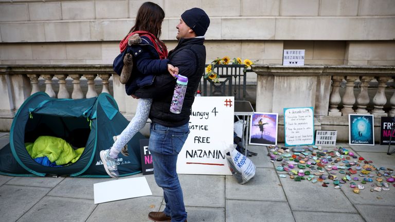 Richard Ratcliffe, husband of British-Iranian aid worker Nazanin Zaghari-Ratcliffe, stands next to his daughter Gabrielle during a second hunger strike, outside the Foreign, Commonwealth and Development Office (FCDO) in London, Britain October 25, 2021. REUTERS/Henry Nicholls
