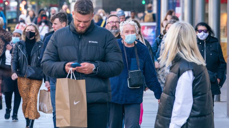 Londra'nın merkezindeki Oxford Caddesi'nde, Sağlık ve Sosyal Bakım Departmanı'nın uygun insanları covid-19 güçlendirici aşılarını yaptırmaya çağırdığı sırada yüz maskeleri takan alışverişçiler.  Resim tarihi: 22 Ekim 2021 Cuma.