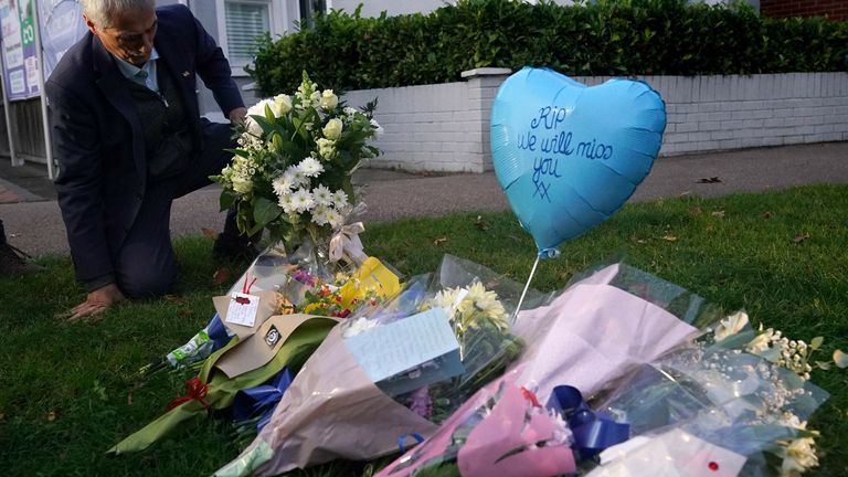 Un homme dépose des fleurs sur les lieux près de l'église méthodiste Belfairs à Eastwood Road North, Leigh-on-Sea, Essex, où le député conservateur Sir David Amess est décédé après avoir été poignardé à plusieurs reprises lors d'une opération chirurgicale de circonscription.  Un homme a été arrêté et les agents ne recherchent personne d'autre.  Date de la photo : vendredi 15 octobre 2021.