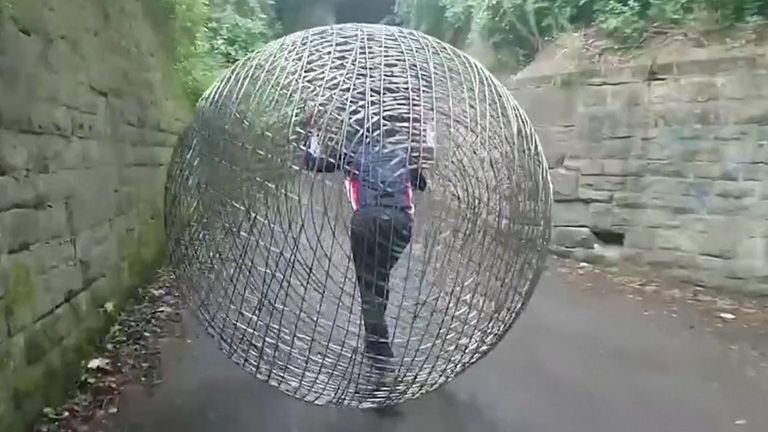 A man walks a metal sphere to COP26