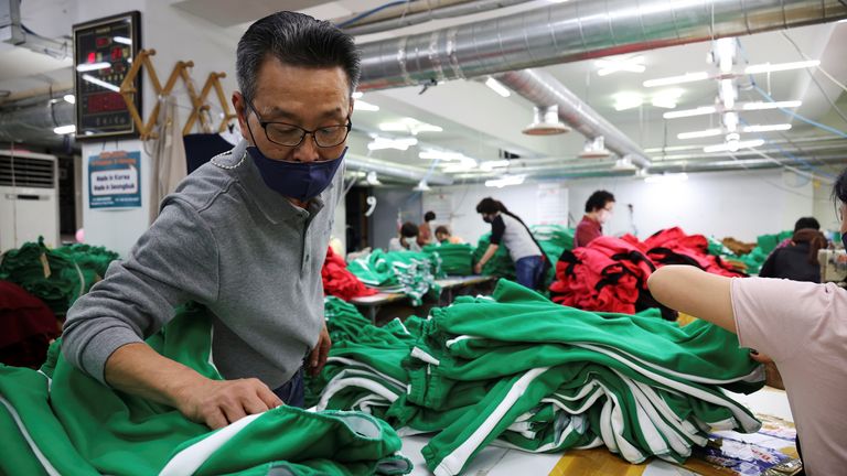 Ko Jong-hyun, 59, a clothing factory owner, checks newly produced tracksuits inspired by Netflix series "Squid Game" at his plant in Seoul, South Korea