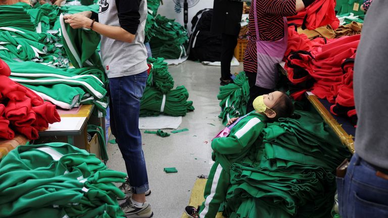 Workers stitch tracksuits inspired by Netflix series "Squid Game" at a clothing factory in Seoul, South Korea
