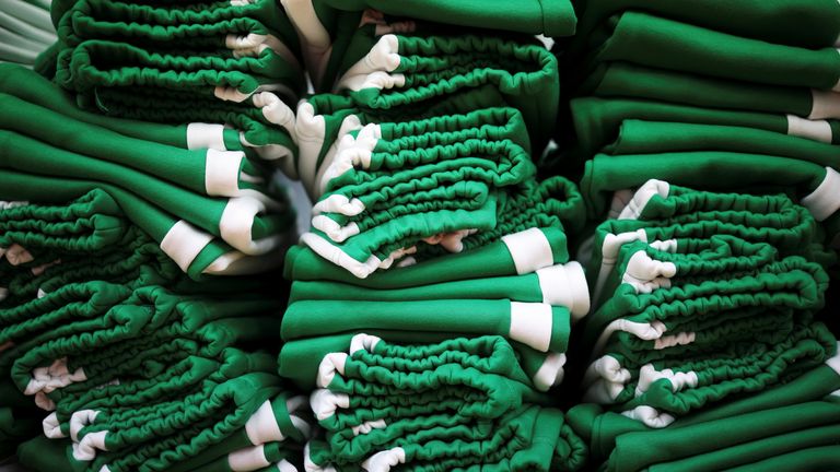 Stacks of green tracksuits at the factory