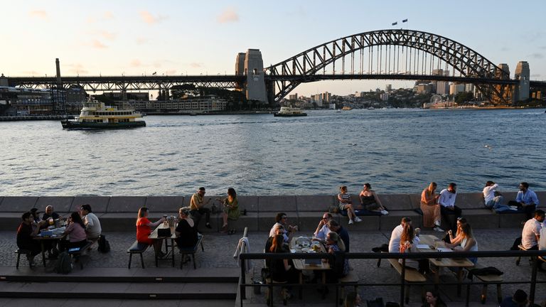 People walk by the harbour in the wake of coronavirus disease (COVID-19) regulations easing, following an extended lockdown to curb an outbreak, in Sydney, Australia, October 22, 2021. REUTERS/Jaimi Joy
