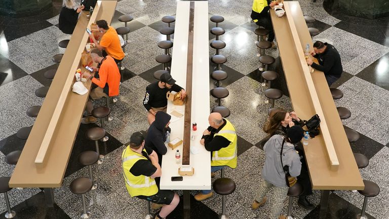 Diners sit to eat at a city centre food court on the first day of eased restrictions for vaccinated patrons, following months of lockdown orders that mandated restaurants only serve take-away and customers couldn't sit to eat at such venues to curb an outbreak of the coronavirus disease (COVID-19), in Sydney, Australia, October 11, 2021. REUTERS/Loren Elliott