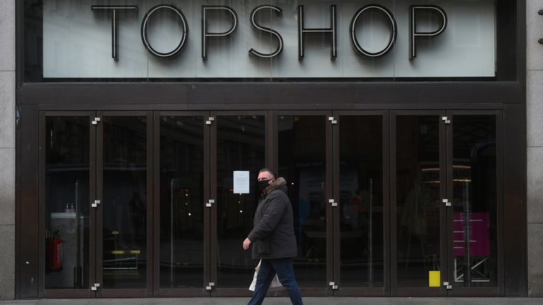 A man walks past the Topshop flagship store at Oxford Circus, London