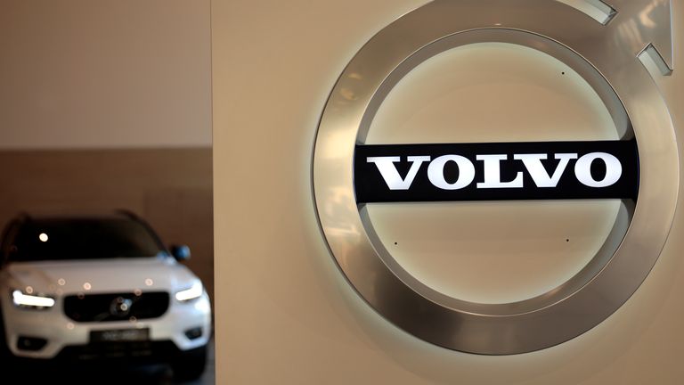 In this Feb. 6, 2020 file photo a Volvo car is parked behind the Volvo logo in the lobby of the company&#39;s corporate headquarters, in Brussels