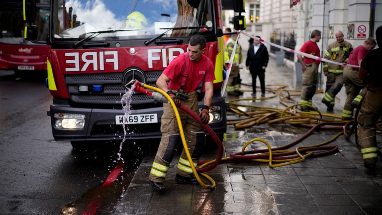 A fire fighter pulls pumping hoses out from the flood damaged Azagury women's fashion designer store after heavy rain in the upmarket Knightsbridge district of central London, Tuesday, Oct. 5, 2021. (AP Photo/Matt Dunham)
PIC:AP