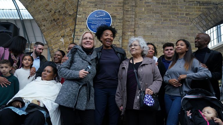 Des proches de Wilston Samuel Jackson, le premier conducteur de train noir britannique, se tiennent sous une plaque commémorative de Jackson après son dévoilement à King's Cross à Londres.  Photo date : lundi 25 octobre 2021.