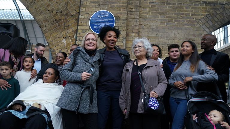 Relatives of Wilston Samuel Jackson, Britain's first black train driver, stand underneath a plaque to commemorate Jackson after it was unveiled at King's Cross in London. Picture date: Monday October 25, 2021.