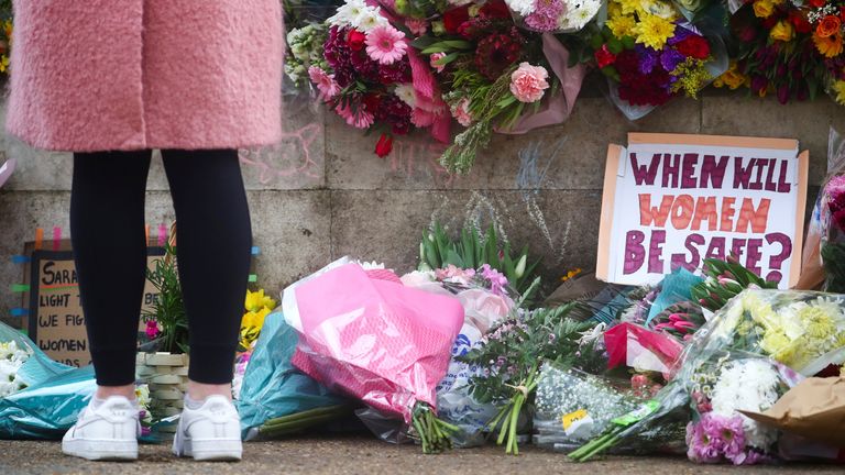 A person stands near flowers at a memorial site in Clapham Common Bandstand, following the kidnap and murder of Sarah Everard, in London, Britain March 13, 2021. REUTERS/Hannah McKay     TPX IMAGES OF THE DAY