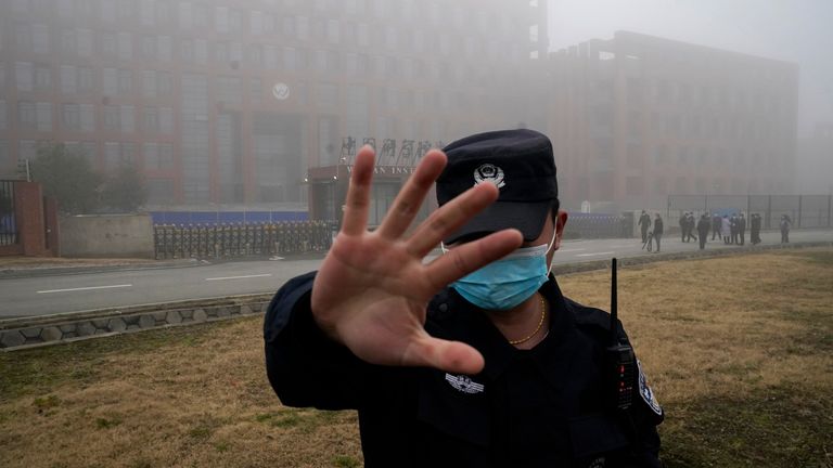 In this Feb. 3, 2021, file photo, a security person moves journalists away from the Wuhan Institute of Virology. Pic: AP