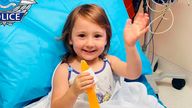 In this photo provided by the Western Australia Police, four-year-old Cleo Smith waves as she sits on a bed in hospital, Wednesday, Nov. 3, 2021, in undisclosed location, Australia. Police smashed their way into a suburban house on Wednesday and rescued Cleo whose disappearance from her family&#39;s camping tent on Australia&#39;s remote west coast more than two weeks ago both horrified and captivated the nation. The seal of Western Australia Police is seen at top left. 
Western Australia Police / AP