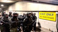 Police in riot gear stand in a garage during a confrontation with protesters in Portland, Oregon, over the Kyle Rittenhouse verdict