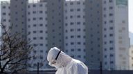 An apartment building is seen behind a medical worker in protective gear at a screening facility for checking coronavirus disease (COVID-19) in Cheongdo county, which has been designated as a 'special care zone' since the coronavirus outbreak, near Daegu in North Gyeongsang Province, South Korea, March 11, 2020. REUTERS/Kim Kyung-Hoon
