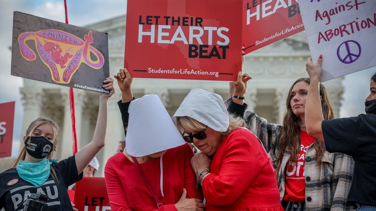 Women dressed as handmaids demonstrate in front of anti-abortion protestors 