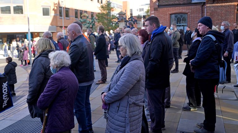 People observe a two minute silence to remember the war dead on Armistice Day by the war memorial in Woking town centre, Surrey. Picture date: Thursday November 11, 2021.
