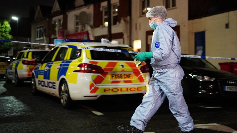 Police at the scene in Albany Parade in Brentford, where a man has been killed and a pensioner is in a critical condition in hospital after they were stabbed in a street in west London